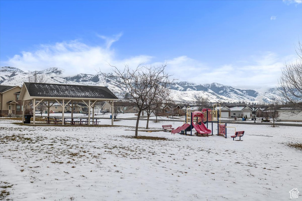 Snow covered playground featuring a mountain view