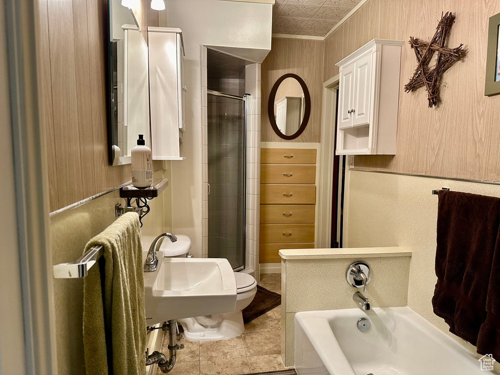 Bathroom featuring shower with separate bathtub, ornamental molding, and tile flooring