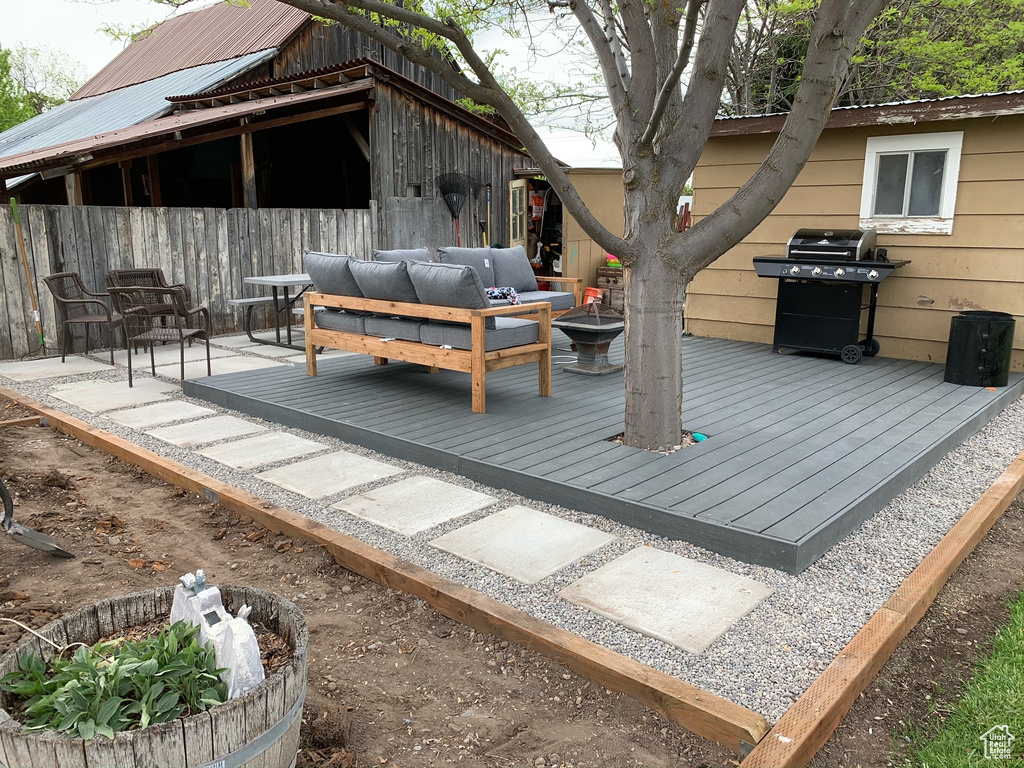 Wooden deck featuring grilling area and an outdoor living space