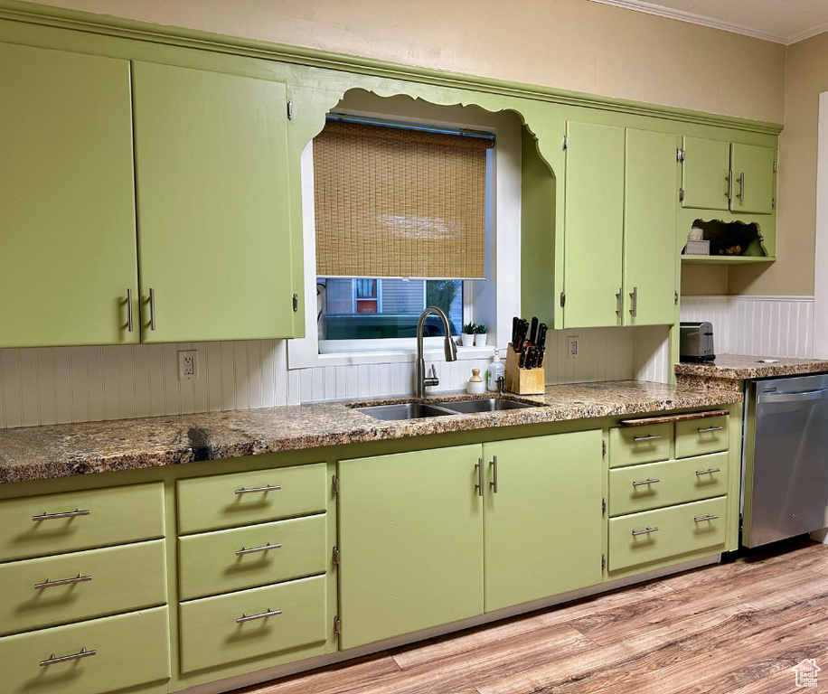 Kitchen with light hardwood / wood-style flooring, dishwasher, crown molding, sink, and green cabinets