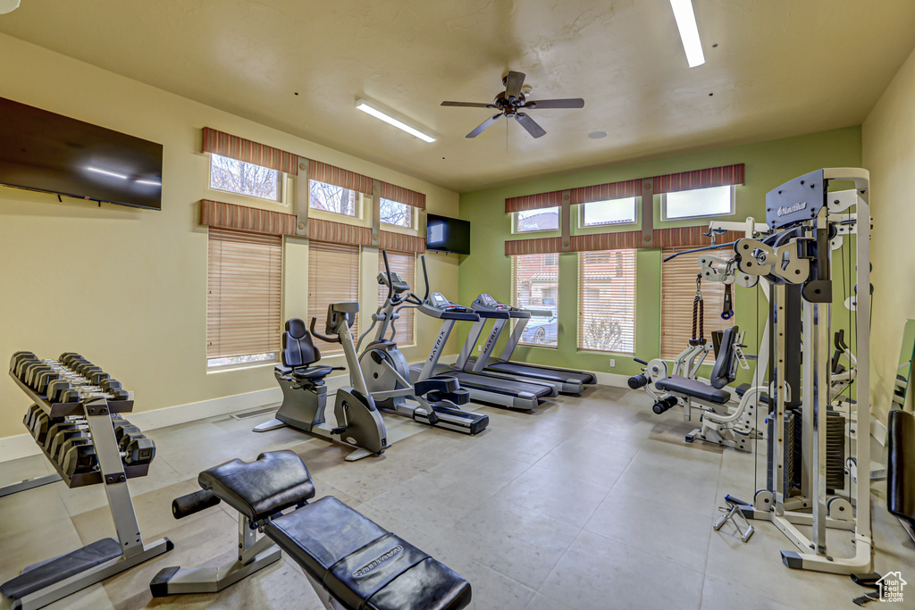 Exercise room featuring light tile floors and ceiling fan