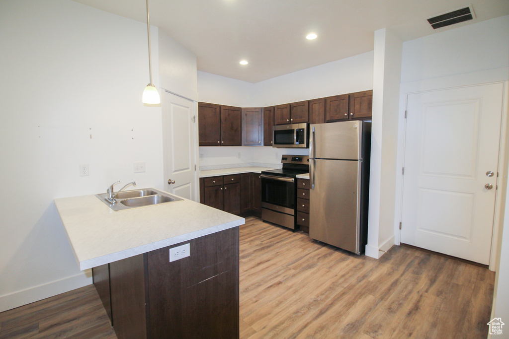 Kitchen featuring light hardwood / wood-style flooring, sink, and appliances with stainless steel finishes