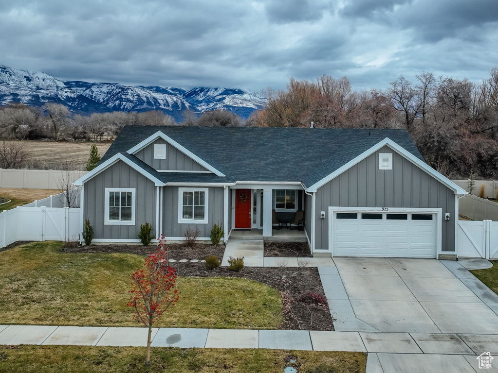View of front of house featuring a front lawn, a garage, and a mountain view