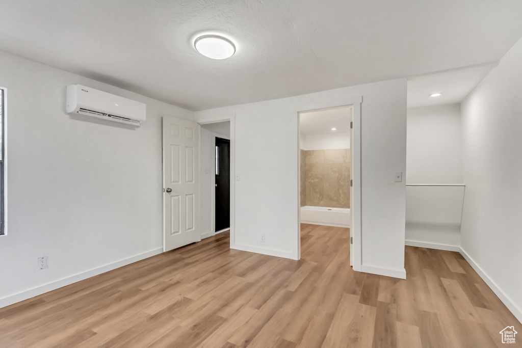 Interior space featuring light hardwood / wood-style floors, ensuite bathroom, and a wall unit AC