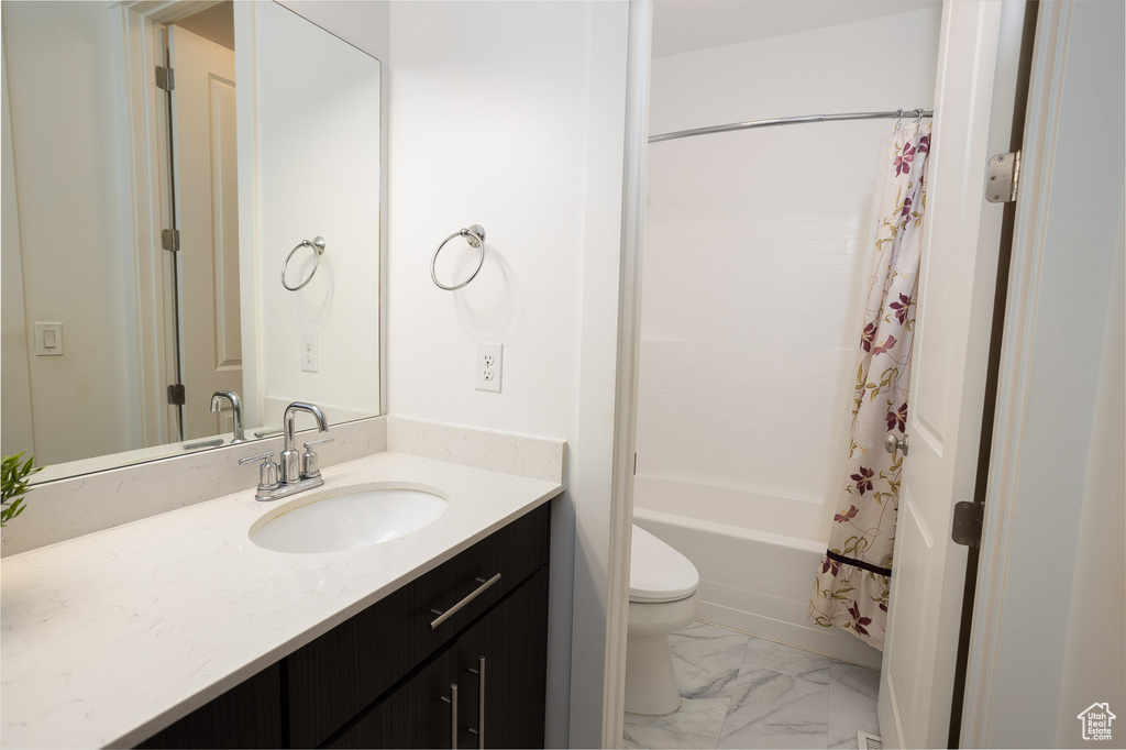 Full bathroom featuring shower / bath combination with curtain, tile floors, oversized vanity, and toilet
