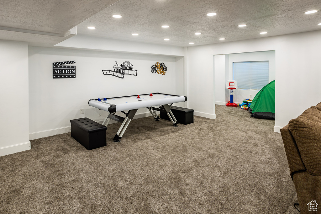 Playroom featuring a textured ceiling and carpet flooring