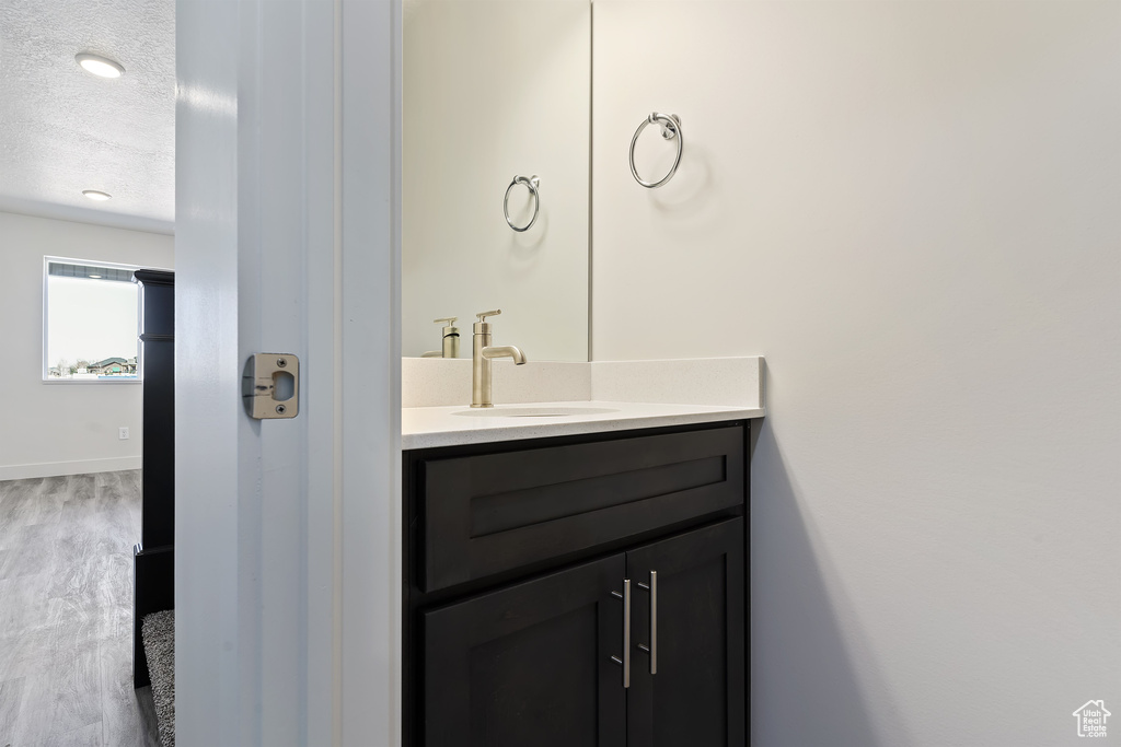 Bathroom featuring vanity, a textured ceiling, and hardwood / wood-style flooring