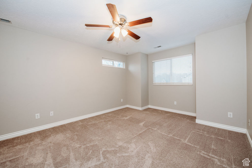 Spare room featuring ceiling fan and light colored carpet