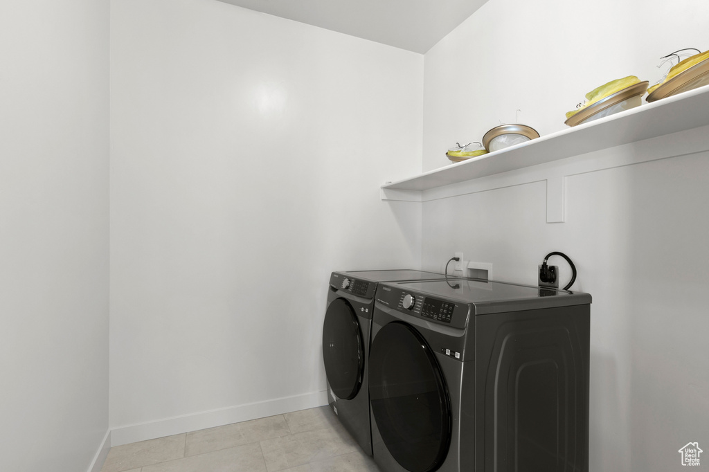 Clothes washing area with washer hookup, light tile flooring, and separate washer and dryer