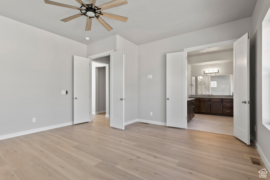 Unfurnished bedroom with connected bathroom, light hardwood / wood-style floors, ceiling fan, and sink