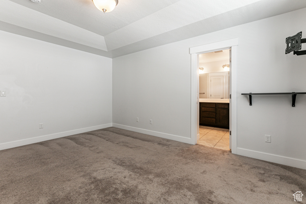 Unfurnished bedroom featuring light carpet and ensuite bath