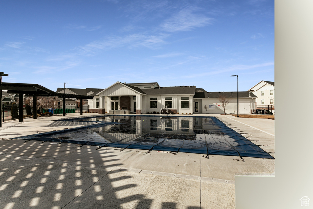 View of front of house with a patio area and a community pool