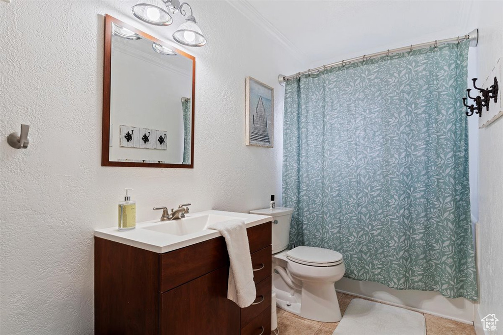 Bathroom with vanity, toilet, ornamental molding, and tile flooring