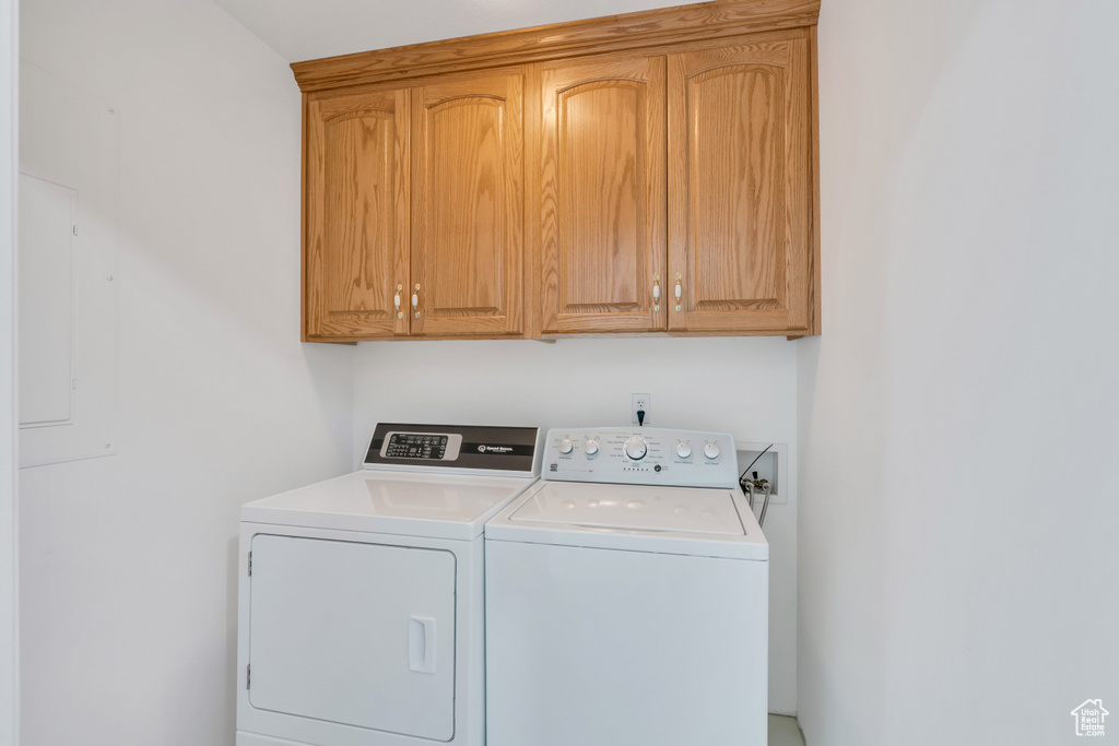 Laundry room with cabinets, washer and clothes dryer, and washer hookup