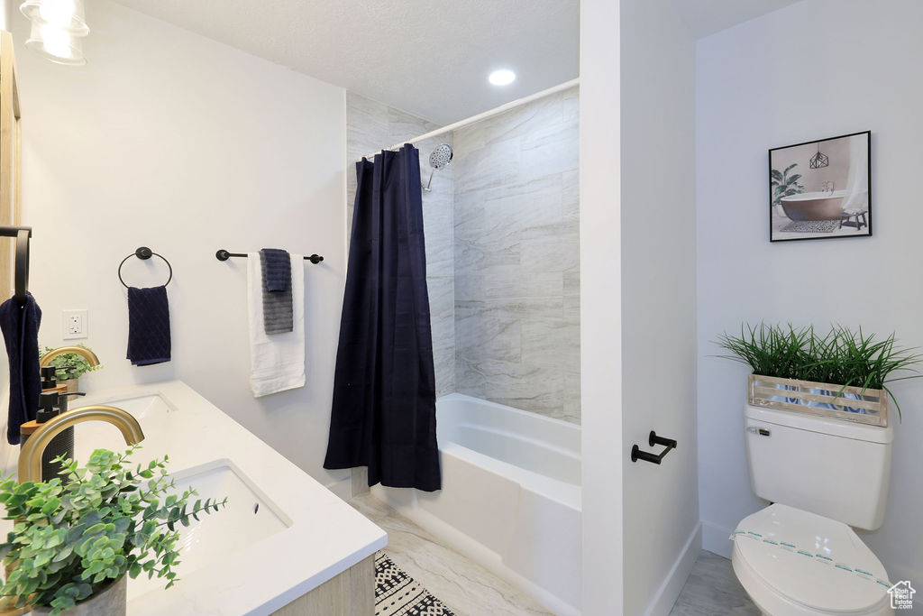 Full bathroom with vanity, shower / bath combination with curtain, tile floors, and toilet