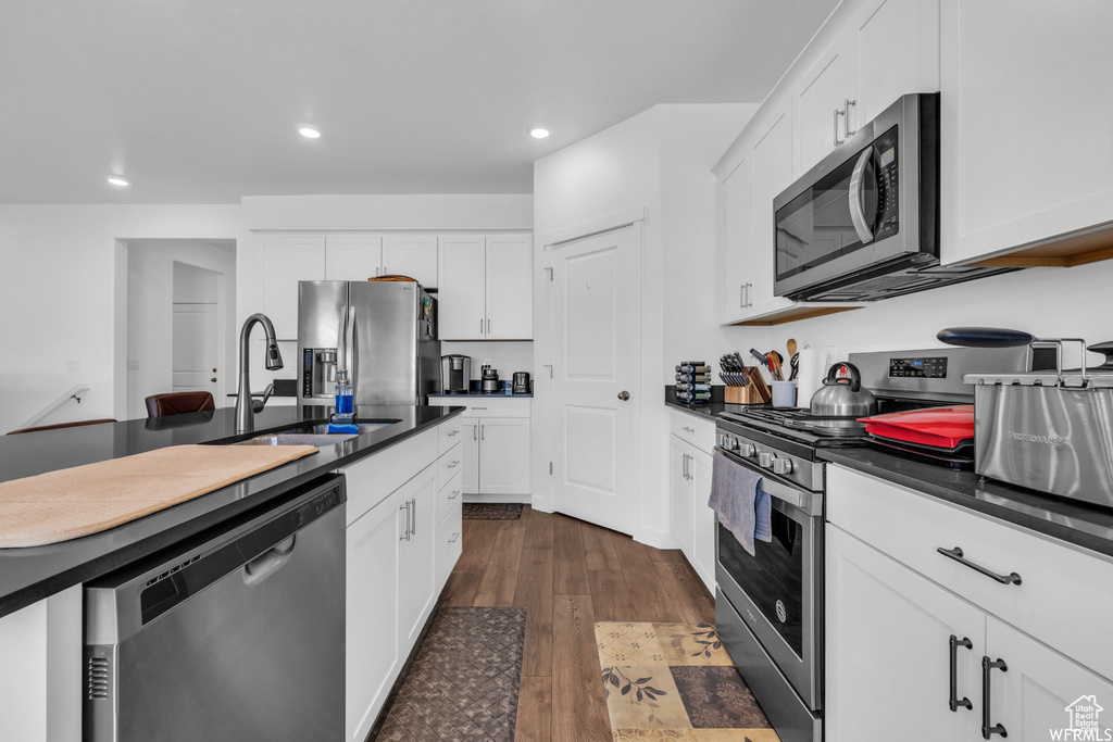 Kitchen featuring white cabinetry, dark hardwood / wood-style flooring, sink, and stainless steel appliances