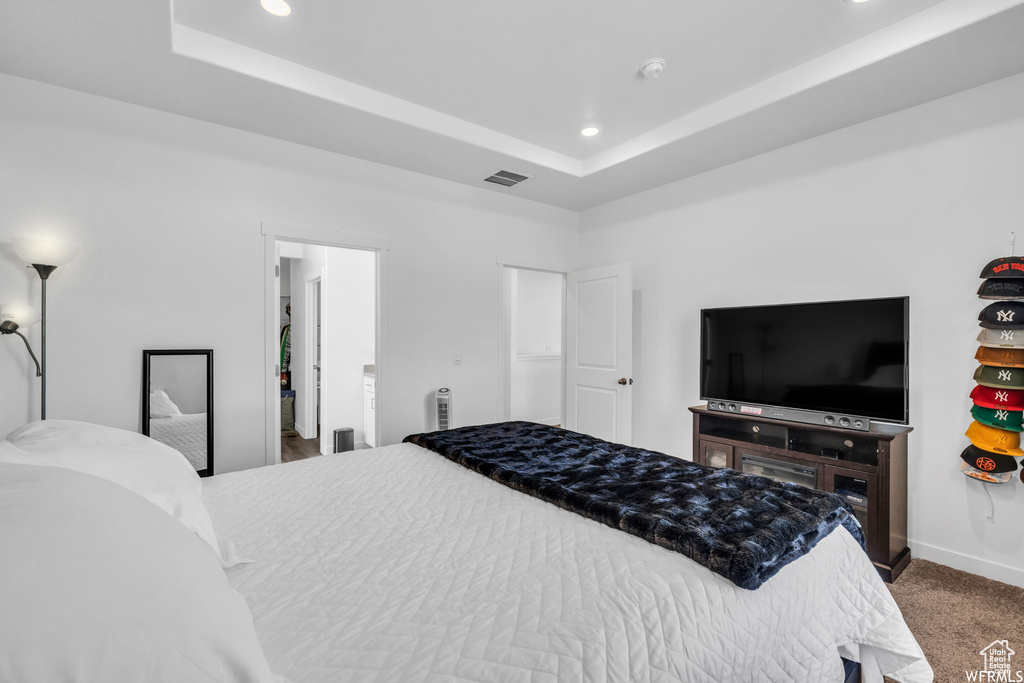 Bedroom featuring dark colored carpet and a tray ceiling