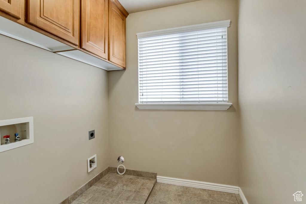 Laundry room with light tile flooring, washer hookup, hookup for an electric dryer, and cabinets