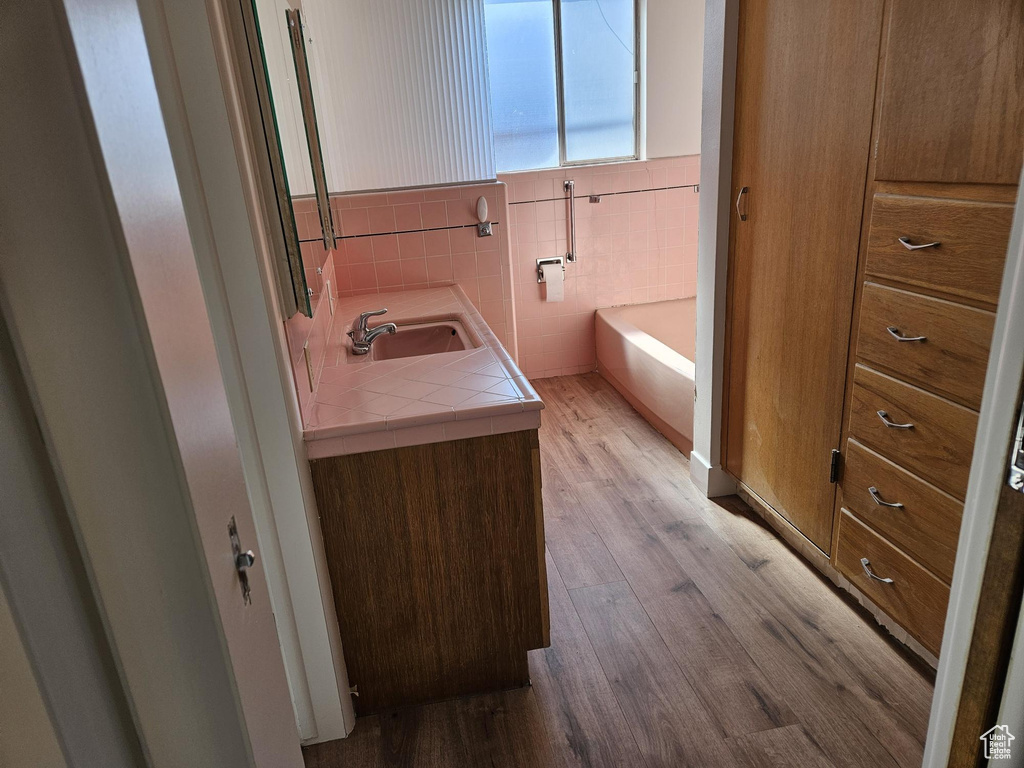 Bathroom featuring a bath, sink, and hardwood / wood-style flooring