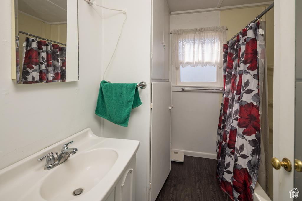 Bathroom with hardwood / wood-style floors, vanity, and shower / bath combo with shower curtain