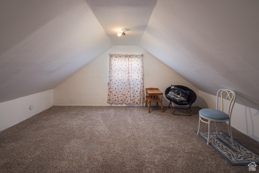 Interior space with dark carpet and vaulted ceiling