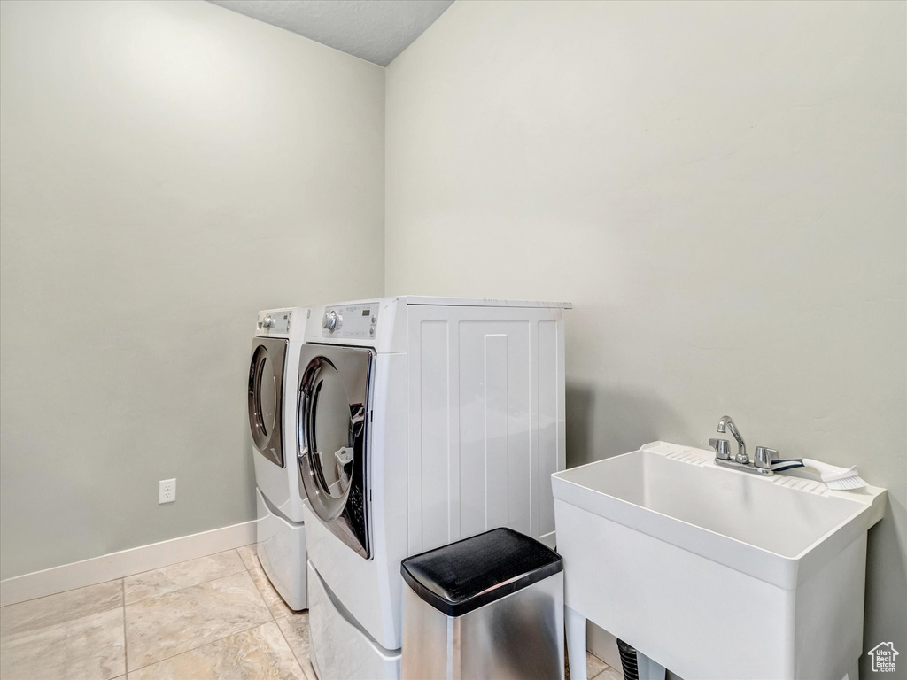 Laundry room featuring sink, independent washer and dryer, and light tile floors