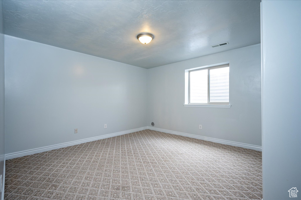 Empty room featuring light colored carpet