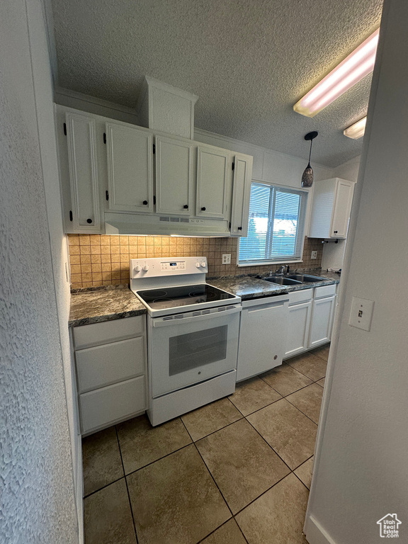 Kitchen featuring dishwasher, backsplash, white cabinets, white electric stove, and light tile floors