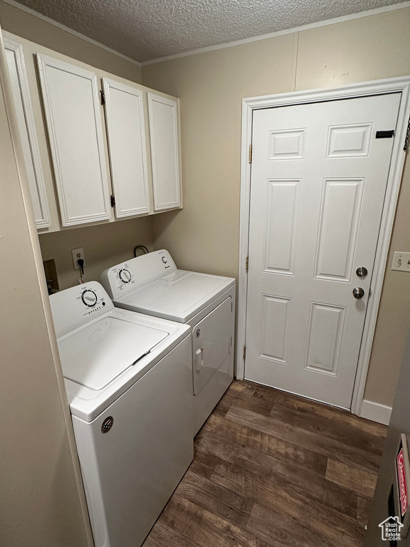 Laundry area featuring dark hardwood / wood-style flooring, washer and dryer, a textured ceiling, and cabinets