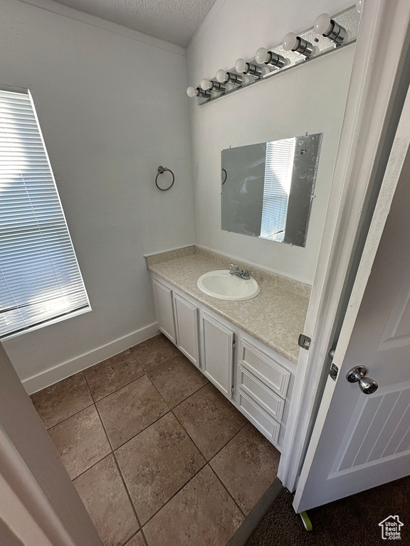 Bathroom featuring vanity, a textured ceiling, and tile floors
