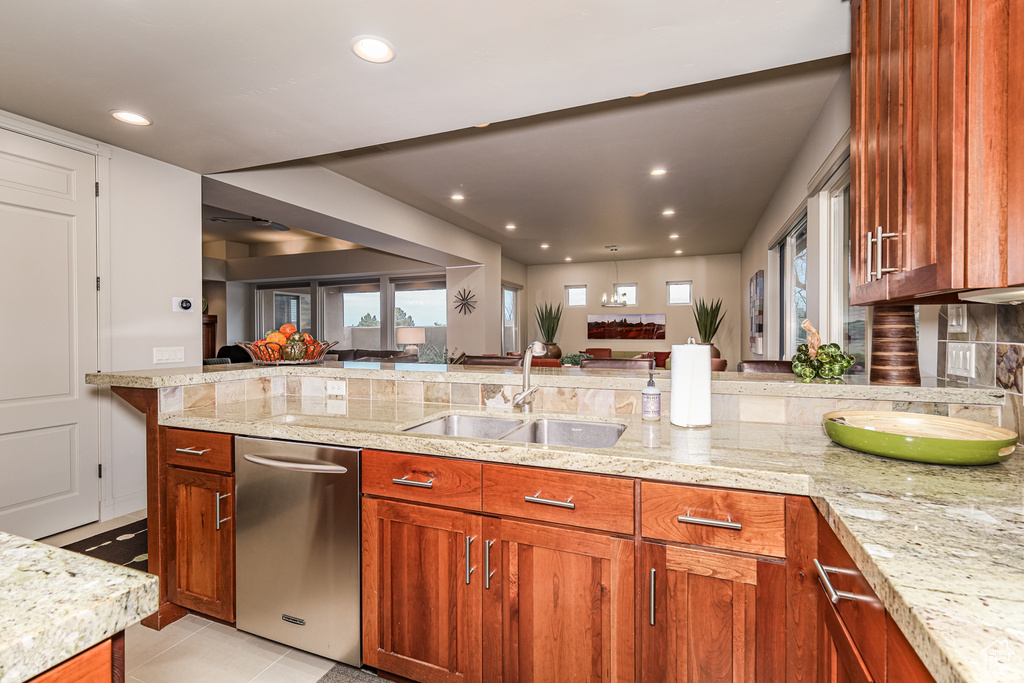 Kitchen with dishwasher, light stone countertops, tasteful backsplash, sink, and light tile flooring