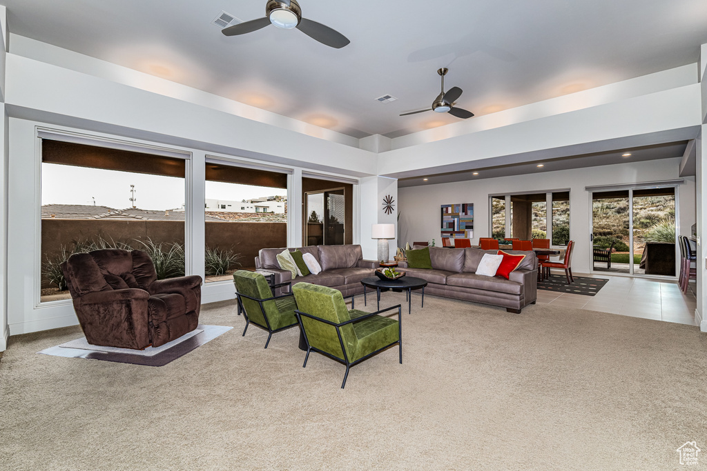 Living room with ceiling fan and light colored carpet