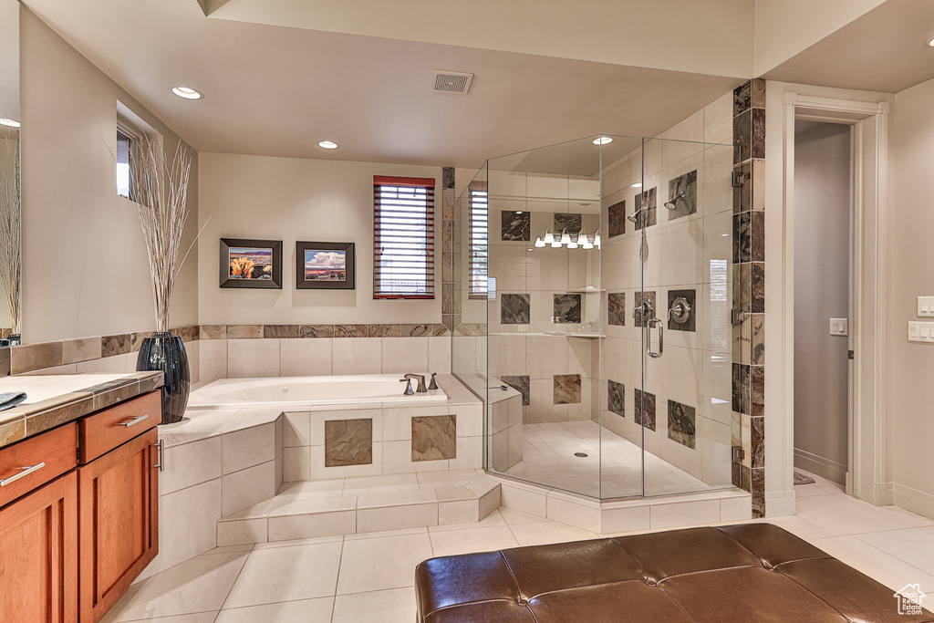 Bathroom with vanity, shower with separate bathtub, and tile flooring