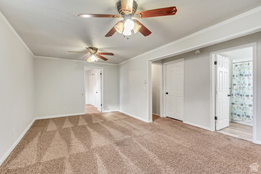 Carpeted spare room featuring crown molding and ceiling fan