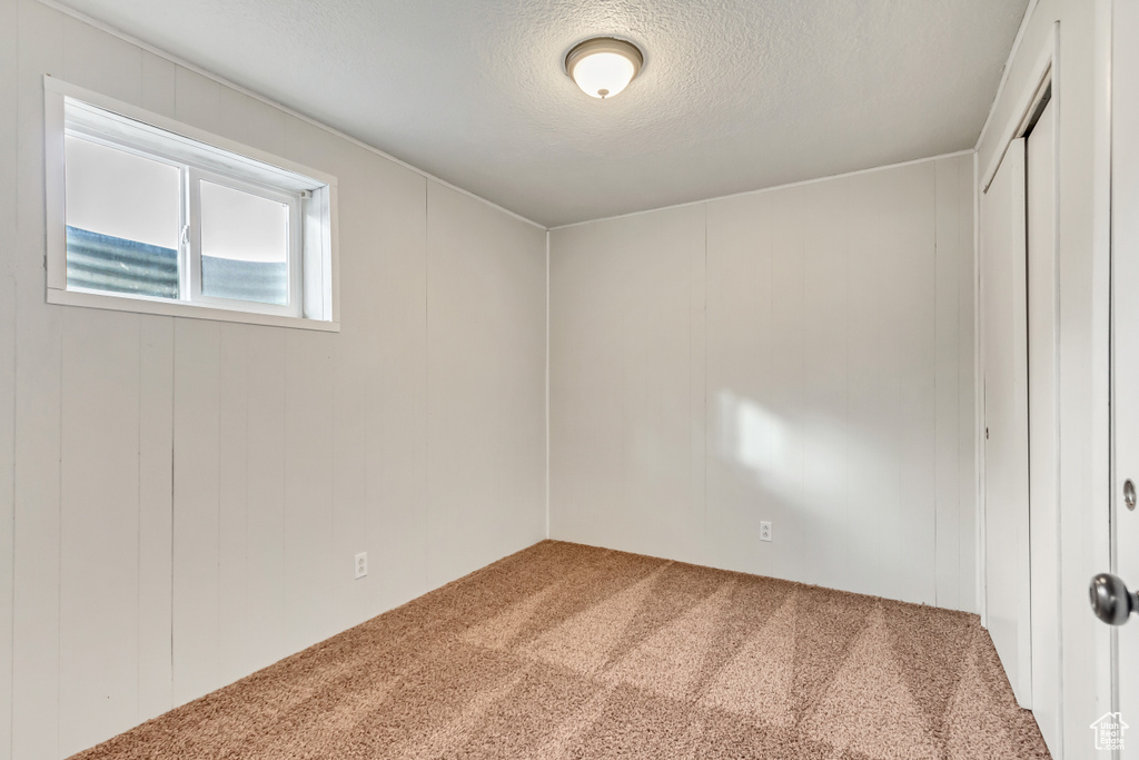 Unfurnished bedroom with a closet, light colored carpet, and a textured ceiling