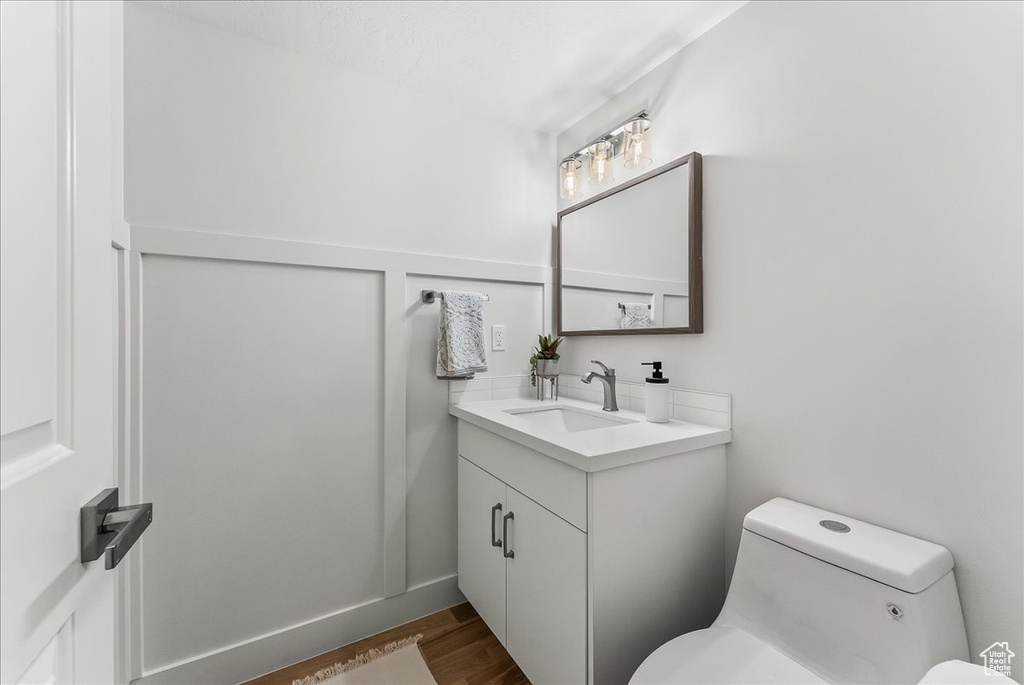 Bathroom with toilet, oversized vanity, and wood-type flooring