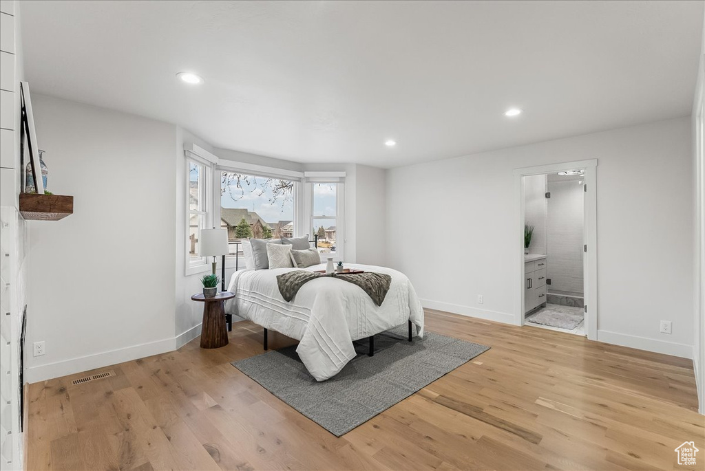 Bedroom featuring light wood-type flooring and ensuite bath