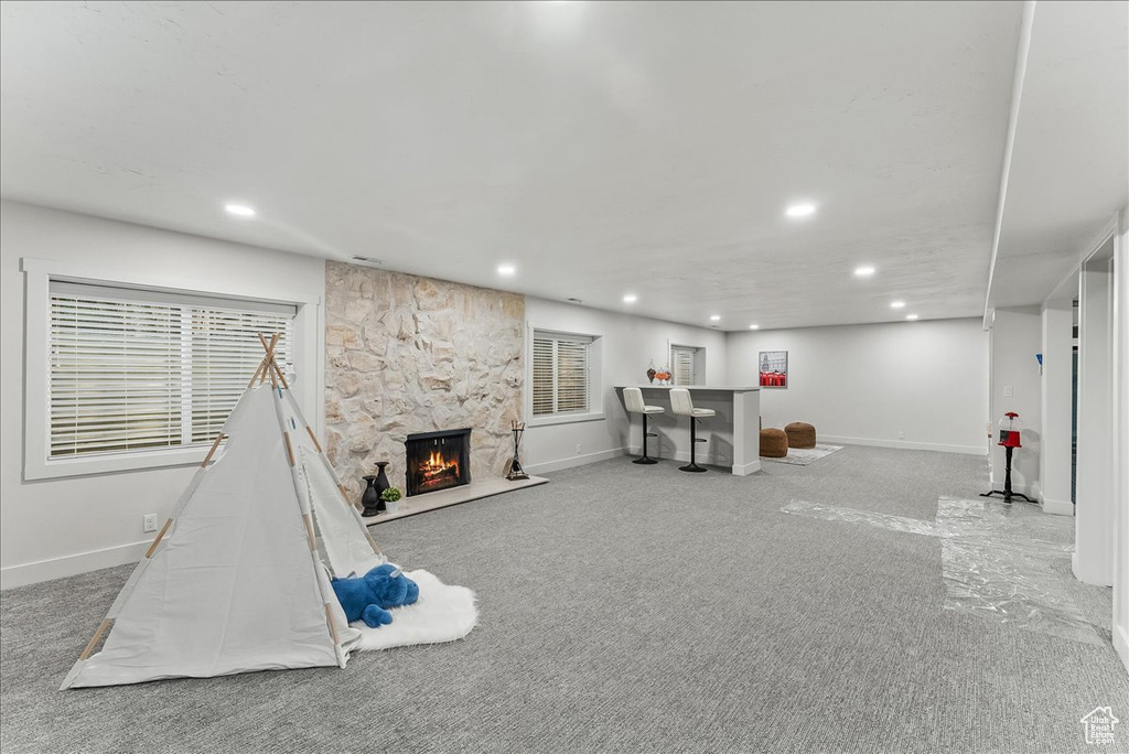 Game room featuring a fireplace and light colored carpet