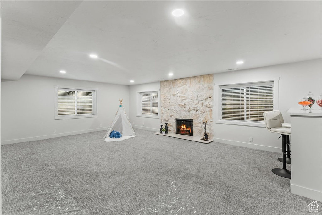 Unfurnished living room featuring a fireplace and light colored carpet