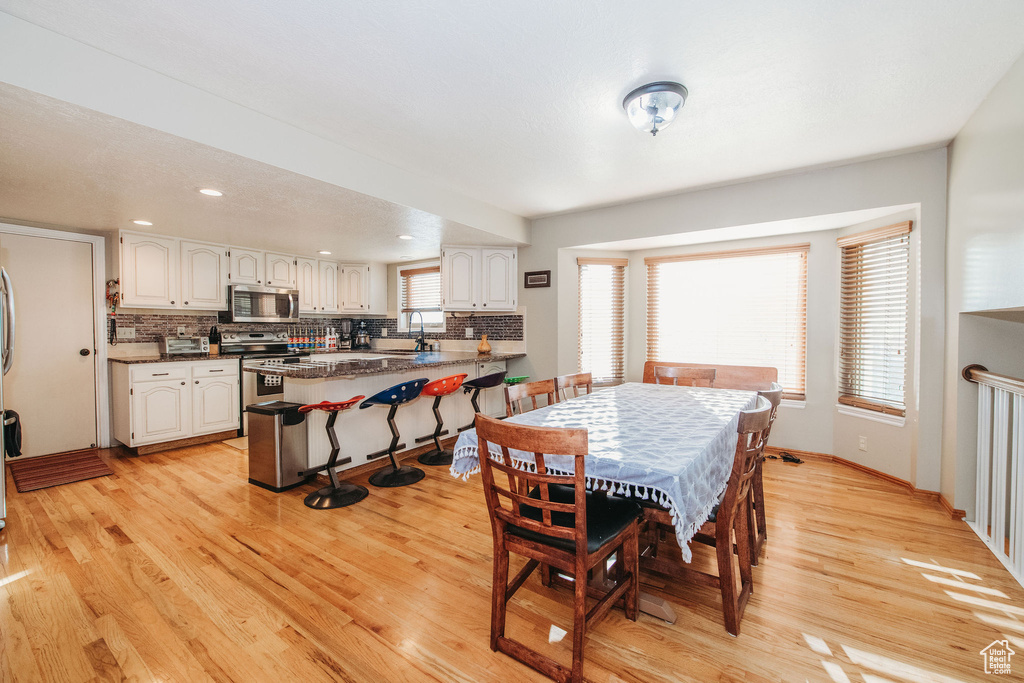Dining room featuring light hardwood / wood-style floors, a healthy amount of sunlight, and sink