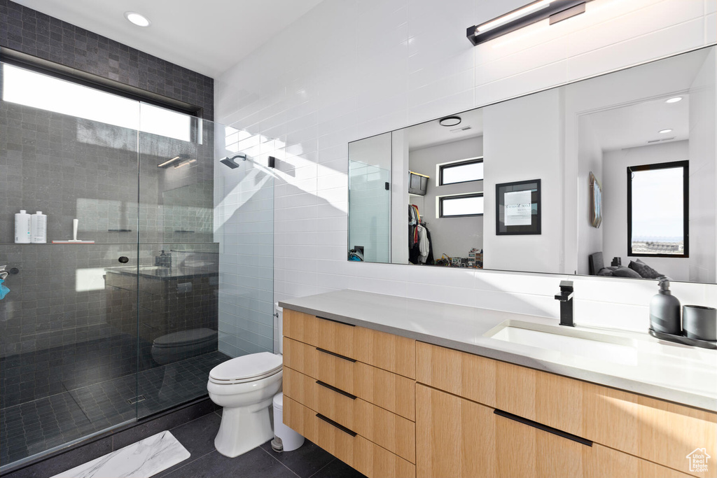 Bathroom with vanity, toilet, tile floors, and plenty of natural light