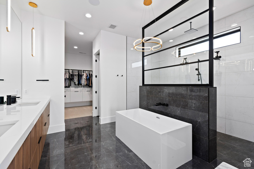 Bathroom with double sink vanity, tile floors, and plus walk in shower