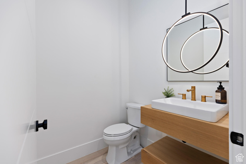 Bathroom featuring sink, toilet, and hardwood / wood-style flooring