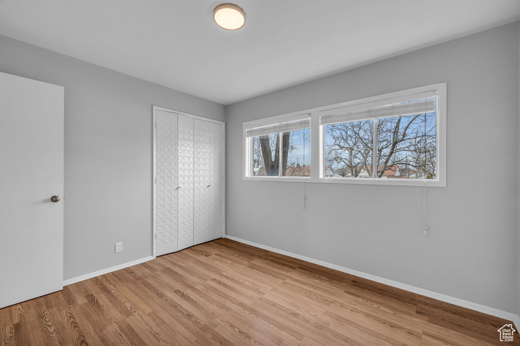 Unfurnished bedroom with light hardwood / wood-style floors and a closet