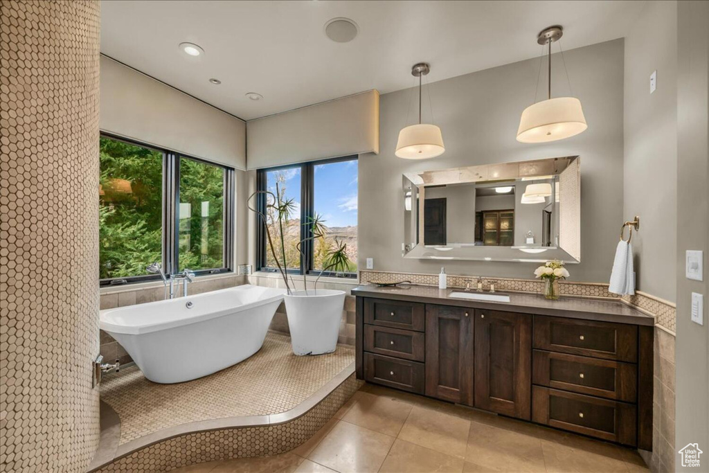 Bathroom featuring vanity, a bathtub, and tile flooring