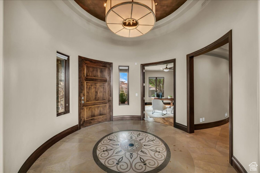 Tiled entryway with a tray ceiling and ceiling fan