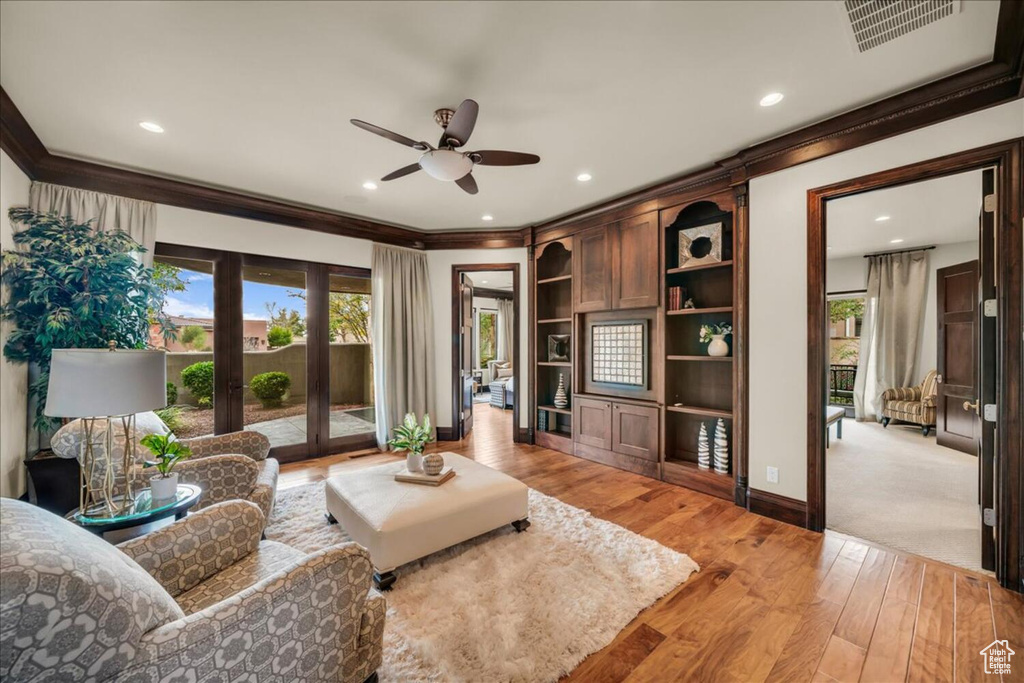 Living room featuring light hardwood / wood-style flooring, ceiling fan, and a healthy amount of sunlight