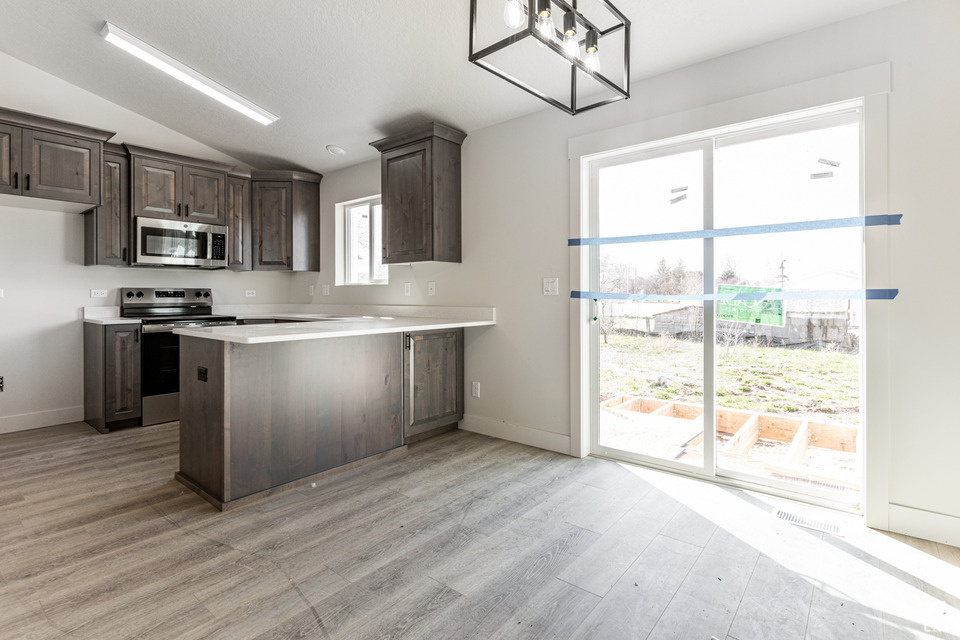 Kitchen featuring plenty of natural light, stainless steel appliances, light hardwood / wood-style flooring, and kitchen peninsula