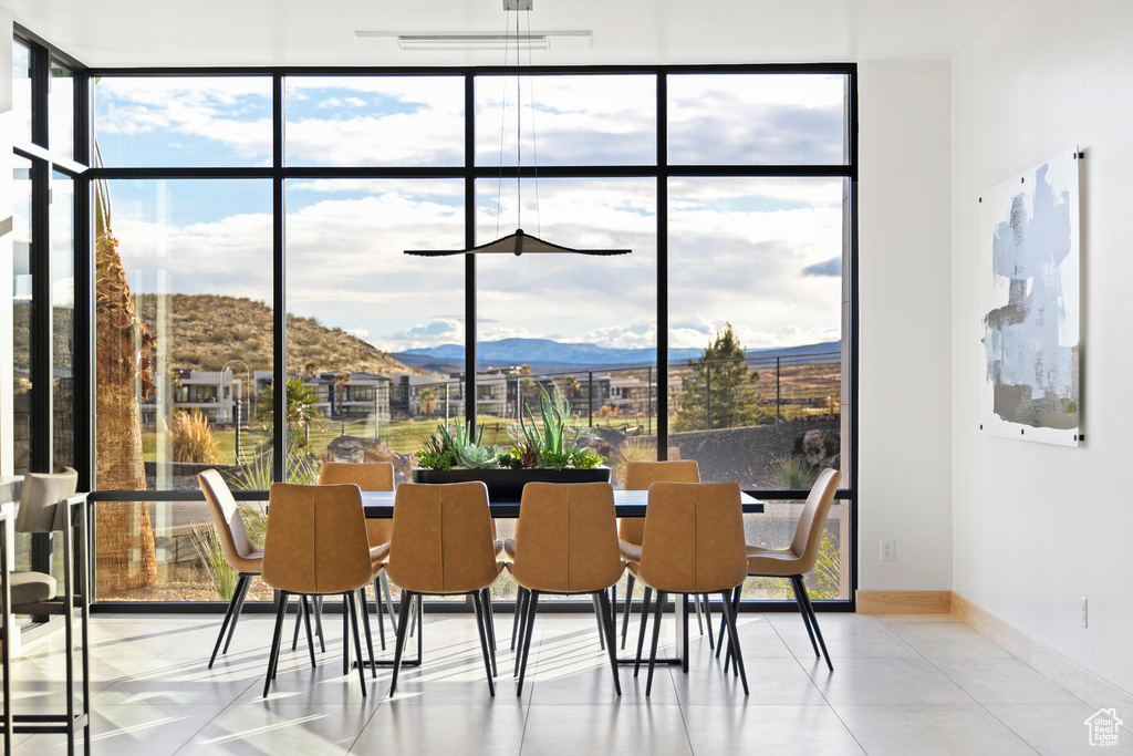 Tiled dining room featuring a mountain view and floor to ceiling windows