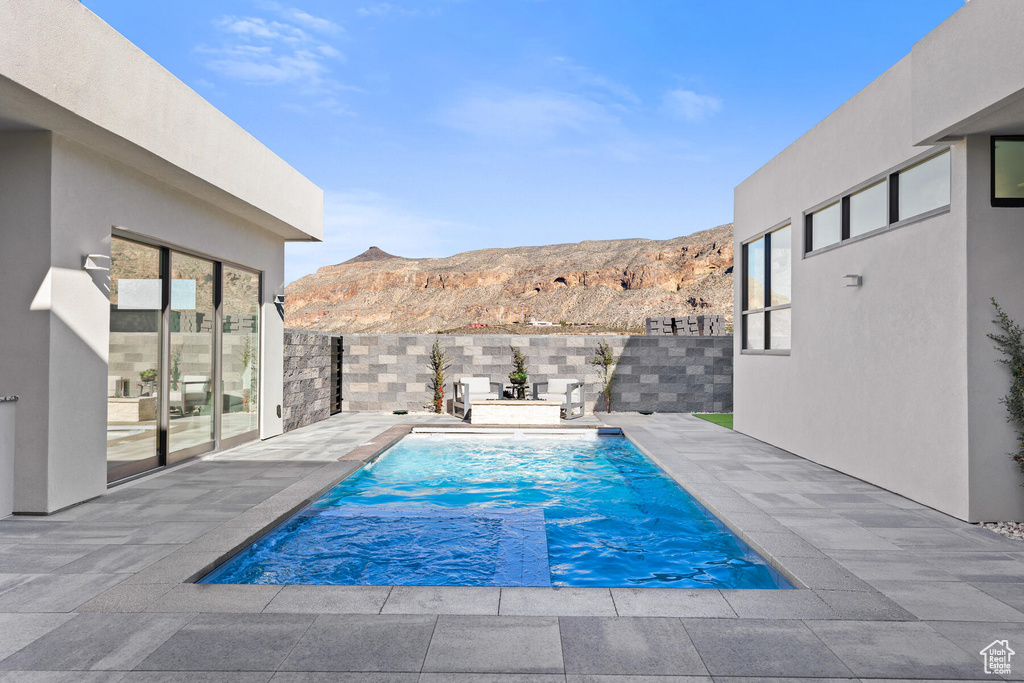 View of pool with a mountain view, a jacuzzi, and a patio area